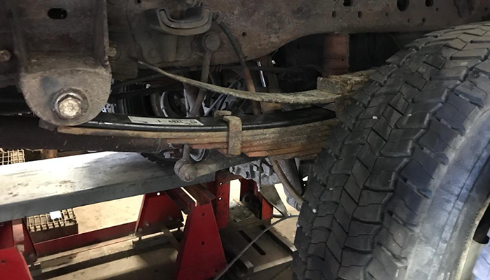 Photo showing extra leaf springs being added to a heavy duty truck at Dias Spring Service in Erie, PA.